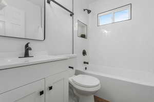 Fully Updated Bathroom with vanity, toilet, and tiled shower / bath