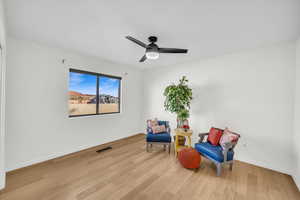 Living area with ceiling fan and light hardwood / wood-style floors