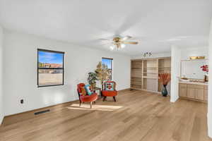 Living area featuring ceiling fan, plenty of natural light, and light wood-type flooring