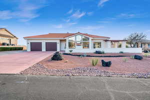 View of front of house featuring central AC and a garage