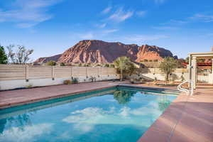 View of pool with a mountain view and a patio area