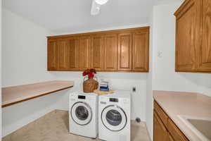 Laundry area with cabinets, washing machine and dryer, and sink