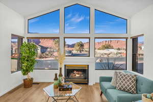 Living room with a mountain view, wood-type flooring, and vaulted ceiling