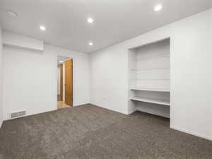 Unfurnished bedroom with dark carpet