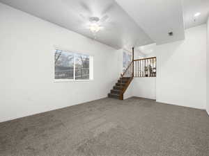 Unfurnished living room with carpet floors and ceiling fan