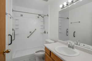 Bathroom with tile patterned floors, vanity, toilet, and walk in shower