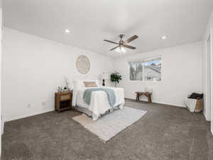 Bedroom featuring ceiling fan and dark colored carpet