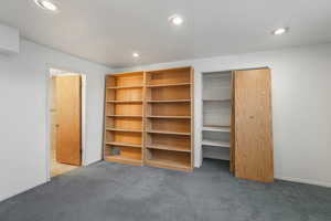 Unfurnished bedroom with dark carpet and a closet