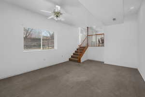 Unfurnished living room featuring carpet and ceiling fan