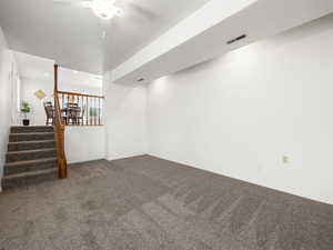 Basement with carpet flooring and ceiling fan