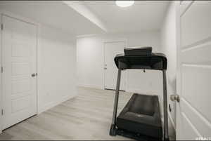 Exercise room with light wood-type flooring