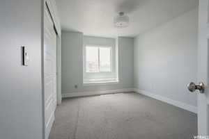 Carpeted spare room featuring a textured ceiling