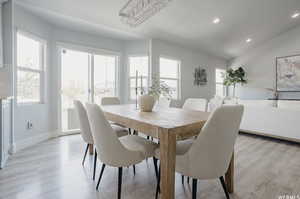 Dining space featuring light hardwood / wood-style floors, an inviting chandelier, and lofted ceiling