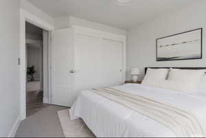 Bedroom featuring light carpet and a closet