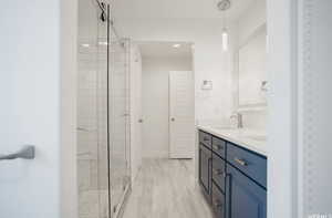 Bathroom featuring vanity and a shower with shower door