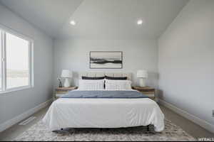 Bedroom featuring carpet flooring, lofted ceiling, and multiple windows