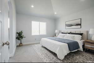 Bedroom featuring light carpet and lofted ceiling