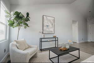 Sitting room with light hardwood / wood-style floors and vaulted ceiling