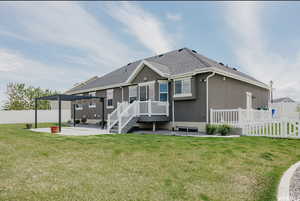 Rear view of house with a pergola, a patio area, and a yard