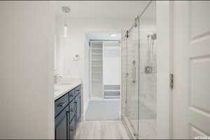 Bathroom featuring vanity and a shower with door