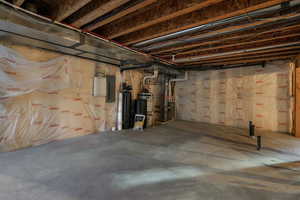 Basement featuring electric panel and water heater