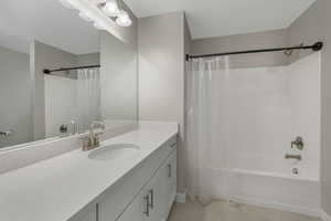 Bathroom featuring tile patterned floors, shower / bath combo, and vanity