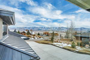 Snow covered patio with a mountain view