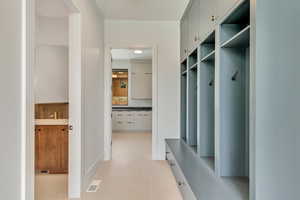 Mudroom open to laundry and powder room