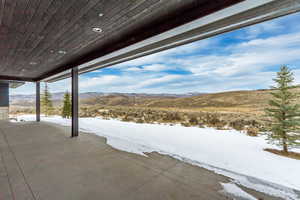 Snow covered patio featuring a mountain view