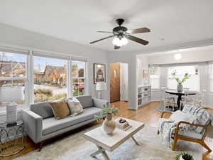 Living room with ceiling fan and light wood flooring