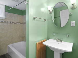 Bathroom with tiled shower / bath and sink