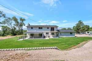 Rear view of house featuring a patio area and a yard