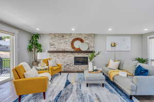 Living room featuring hardwood / wood-style flooring and a stone fireplace