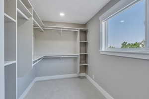 Spacious closet with light colored carpet