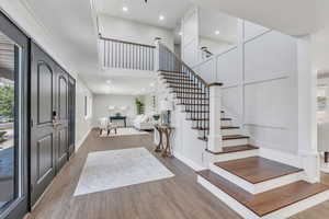 Entrance foyer with wood-type flooring and a high ceiling