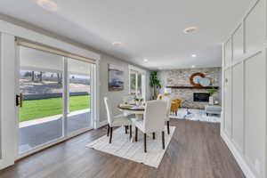 Dining room featuring hardwood / wood-style flooring and a stone fireplace