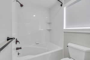 Bathroom featuring washtub / shower combination and toilet