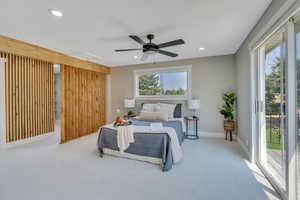 Bedroom with access to exterior, ceiling fan, light carpet, and multiple windows