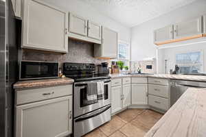 Kitchen featuring light tile patterned floors, stainless steel appliances, a wealth of natural light, and sink