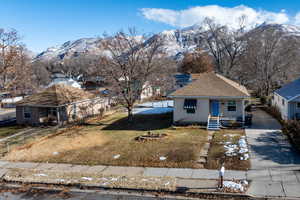 View of front of property featuring a mountain view, a porch, and a front lawn