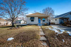 View of front of house with a porch and a front yard