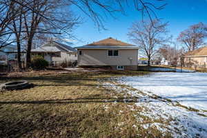 Snow covered property featuring a yard and an outdoor fire pit