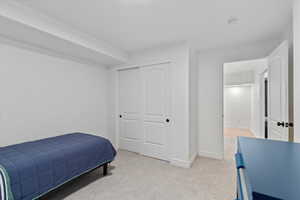 Carpeted bedroom featuring a closet