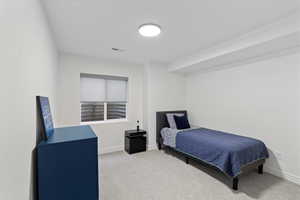 Bedroom featuring light colored carpet