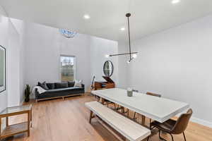 Dining space with a chandelier and light hardwood / wood-style flooring