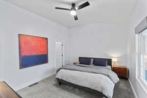 Bedroom featuring multiple windows, ceiling fan, carpet, and vaulted ceiling