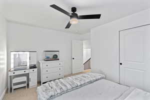 Carpeted bedroom with ceiling fan