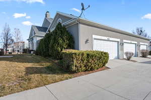 View of side of property with a yard and a garage