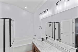 Bathroom with vanity, separate shower and tub, and vaulted ceiling