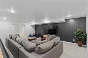 Living room featuring wood walls and light carpet